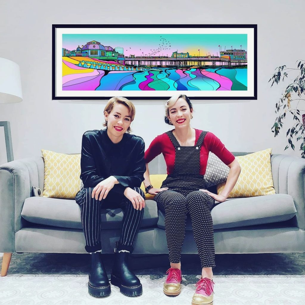 Artists, Two Faced Twins, in front of their painting Making Memories